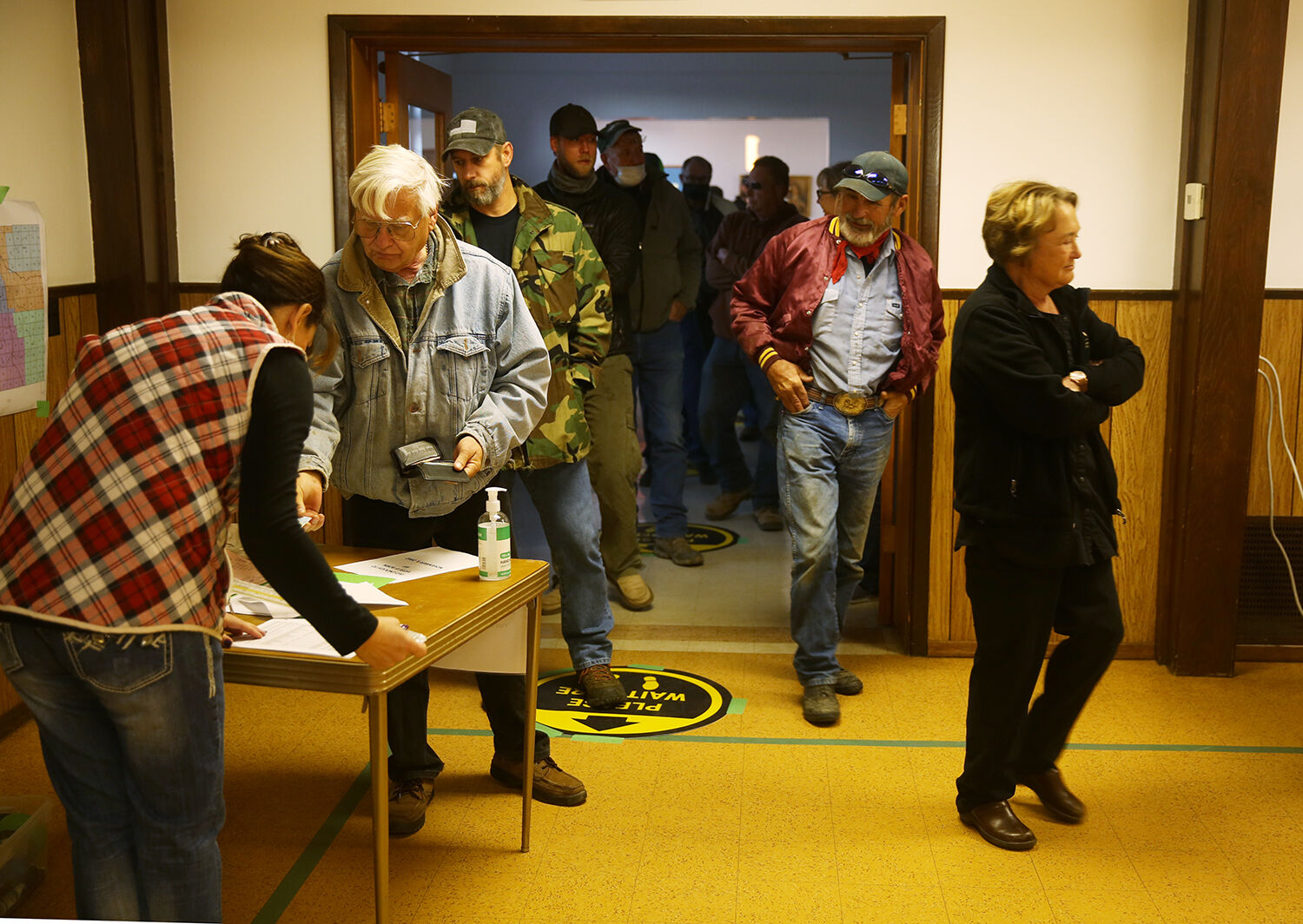 Voters stop at the front table to check their precinct